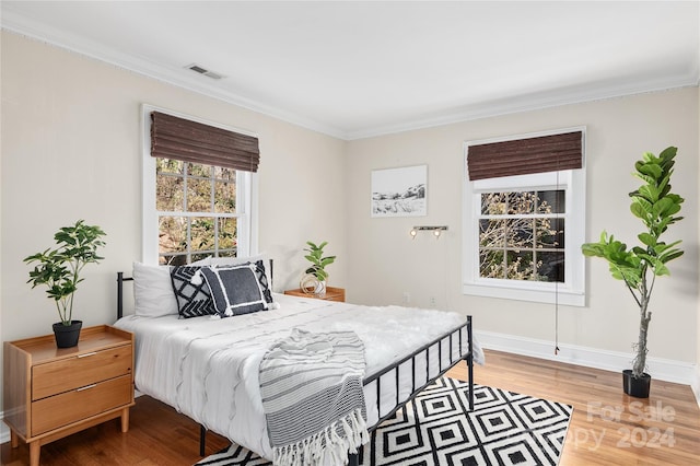 bedroom with hardwood / wood-style flooring and ornamental molding