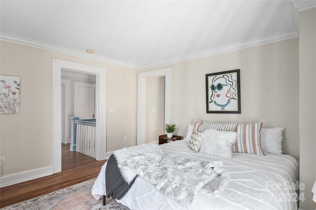 bedroom featuring crown molding and dark hardwood / wood-style floors