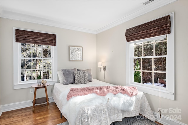 bedroom featuring wood-type flooring and crown molding