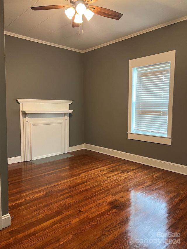 empty room with a ceiling fan, dark wood-type flooring, baseboards, and ornamental molding