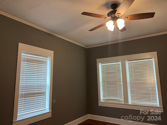 empty room featuring a ceiling fan, baseboards, and ornamental molding