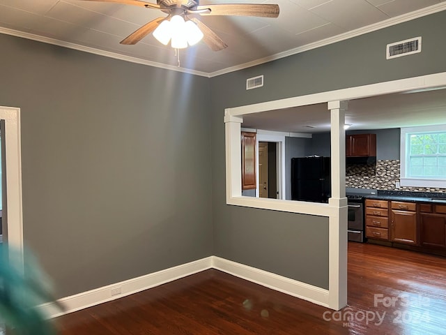 empty room featuring crown molding, baseboards, visible vents, and dark wood-style flooring