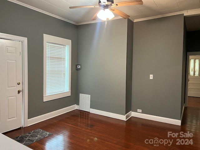 unfurnished room featuring crown molding, baseboards, and wood finished floors