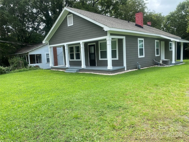 back of property featuring a yard, covered porch, and central air condition unit