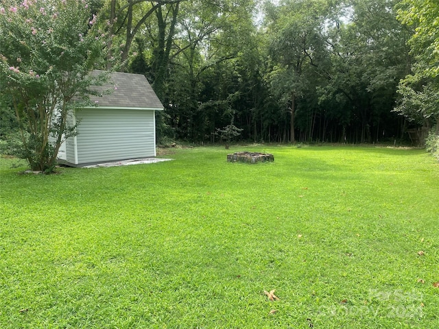 view of yard featuring a storage shed and an outbuilding