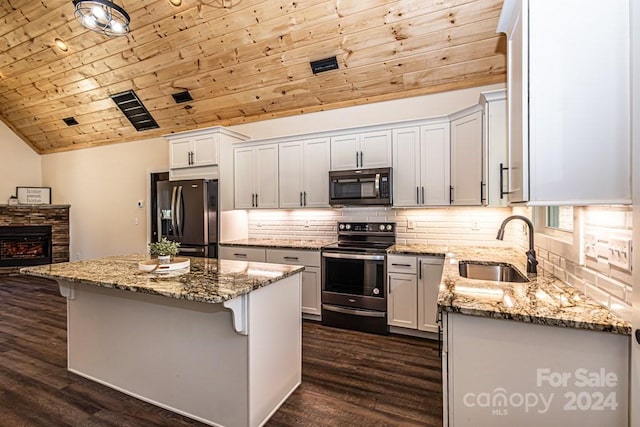 kitchen featuring a kitchen island, dark hardwood / wood-style flooring, stainless steel appliances, and white cabinets