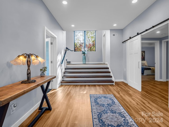 interior space with a barn door and wood-type flooring