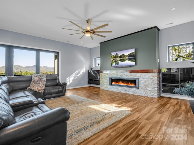 living room with a mountain view, plenty of natural light, wood-type flooring, and a fireplace