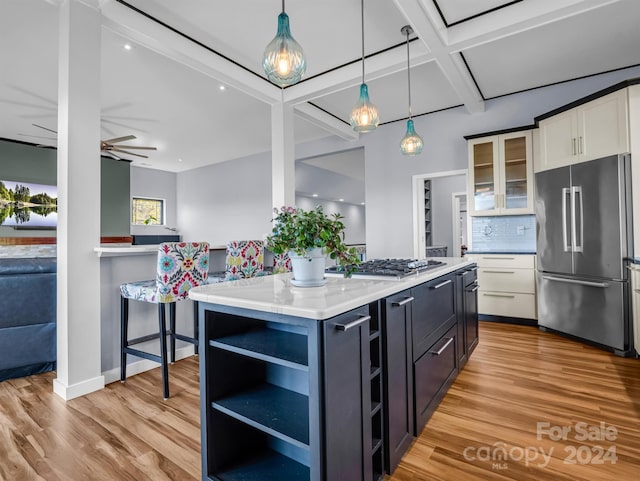 kitchen featuring white cabinetry, stainless steel appliances, backsplash, a kitchen island, and pendant lighting