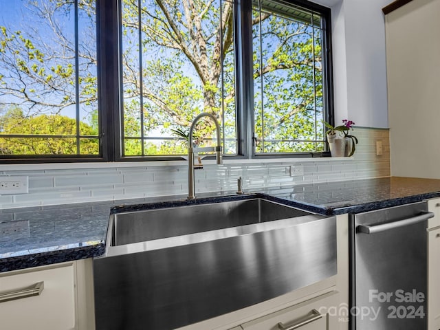 kitchen featuring sink, white cabinetry, backsplash, and a healthy amount of sunlight