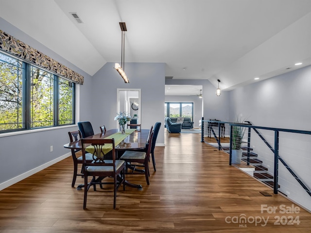 dining space with dark wood-type flooring and vaulted ceiling