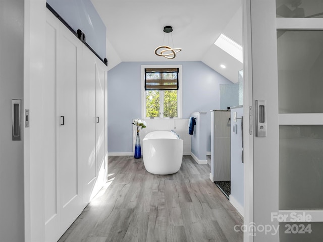 bathroom featuring hardwood / wood-style flooring, lofted ceiling with skylight, and plus walk in shower