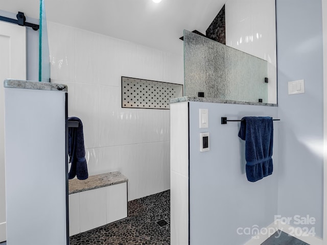 bathroom with a shower and tile walls