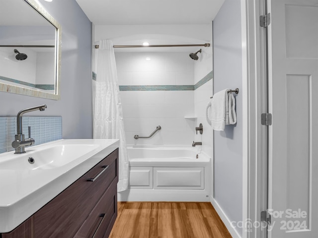 bathroom with hardwood / wood-style floors, vanity, and shower / bath combo with shower curtain