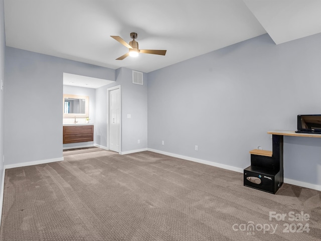 unfurnished living room featuring carpet floors and ceiling fan