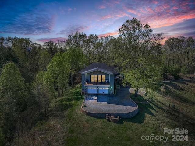 back house at dusk with a lawn