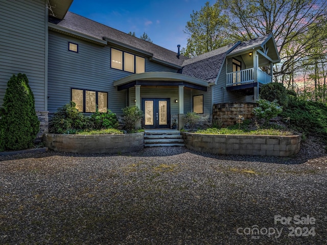 view of front of house with french doors and a balcony