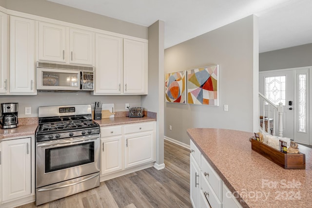 kitchen featuring white cabinetry, stainless steel appliances, and light hardwood / wood-style floors