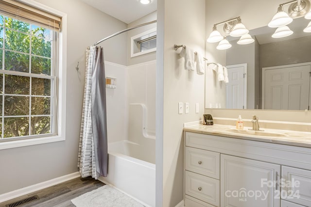 bathroom featuring hardwood / wood-style floors, vanity, and shower / bath combo with shower curtain