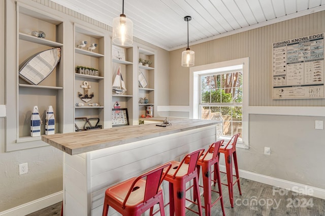 bar with butcher block counters, crown molding, wood ceiling, and decorative light fixtures