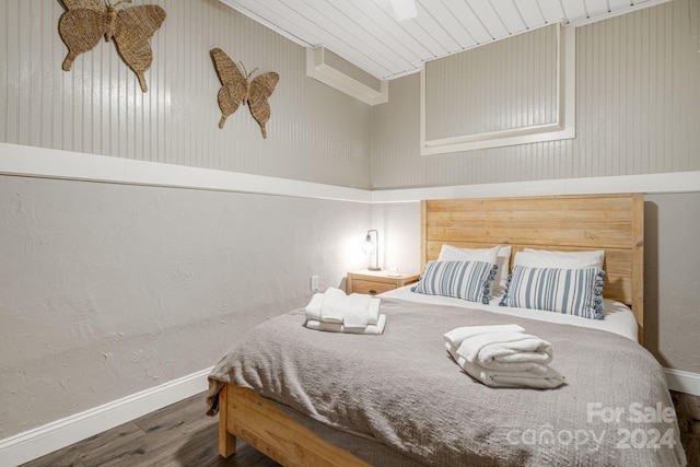 bedroom featuring hardwood / wood-style floors, wooden walls, and wooden ceiling