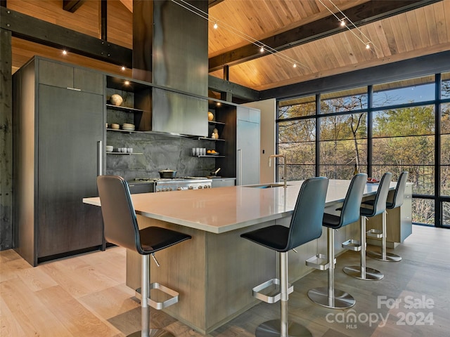 kitchen featuring backsplash, wood ceiling, sink, light wood-type flooring, and a breakfast bar