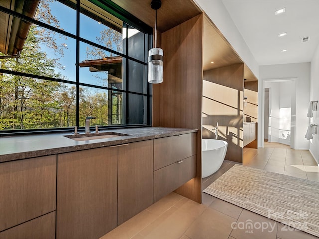 interior space with floor to ceiling windows, a bath to relax in, tile floors, and vanity