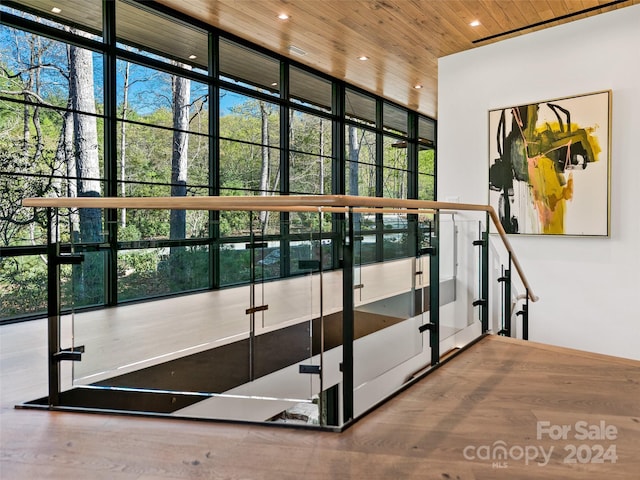 interior space featuring a wall of windows, hardwood / wood-style flooring, a wealth of natural light, and wood ceiling