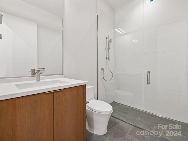 bathroom with a shower with door, toilet, tile flooring, and vanity