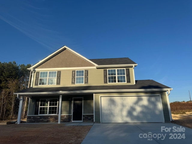 view of front of home featuring a porch and a garage