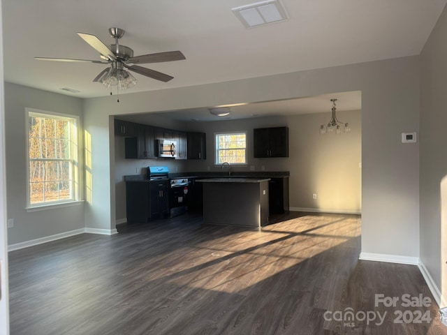 kitchen featuring sink, ceiling fan with notable chandelier, dark hardwood / wood-style flooring, and range with electric cooktop