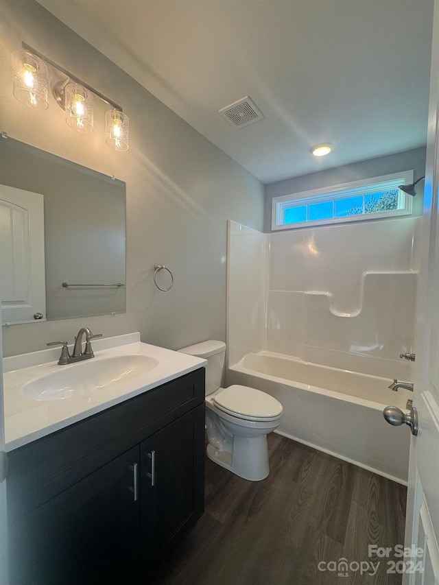 full bathroom featuring vanity, hardwood / wood-style floors, shower / bathing tub combination, and toilet