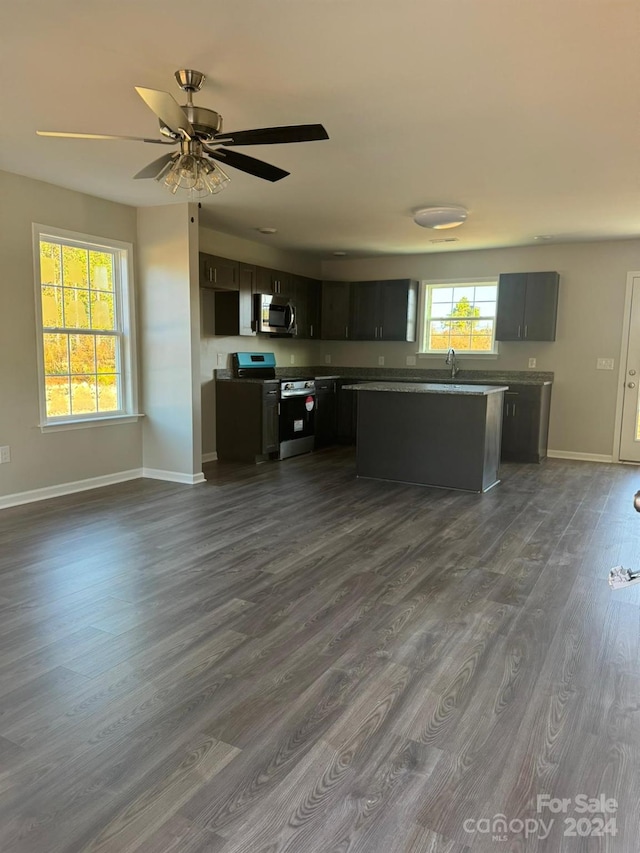 kitchen with sink, a center island, ceiling fan, stainless steel appliances, and dark hardwood / wood-style floors