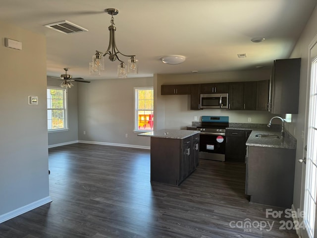 kitchen featuring appliances with stainless steel finishes, a healthy amount of sunlight, sink, and a kitchen island