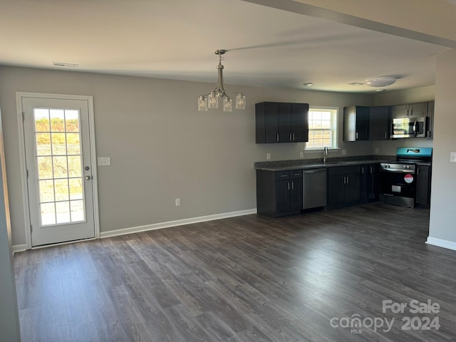 kitchen featuring appliances with stainless steel finishes, a notable chandelier, dark hardwood / wood-style floors, and a healthy amount of sunlight