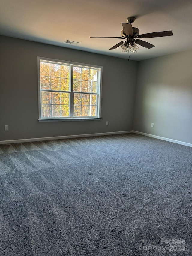 carpeted spare room featuring ceiling fan