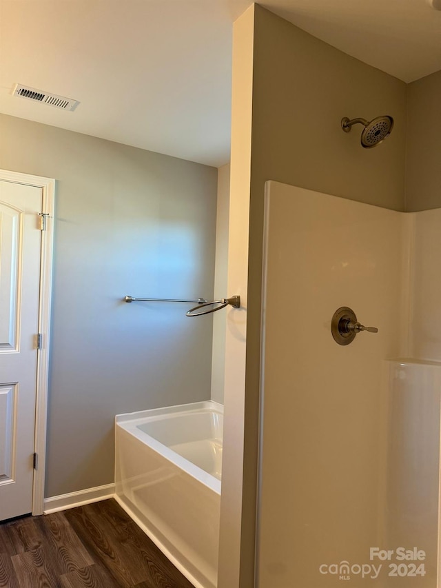 bathroom featuring independent shower and bath and hardwood / wood-style floors