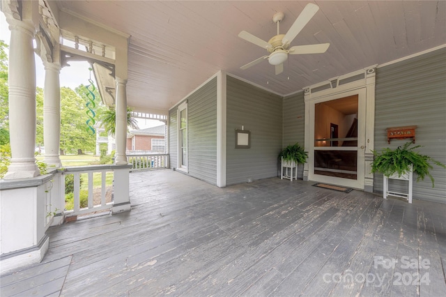 wooden terrace featuring covered porch and ceiling fan