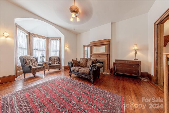 living room with ceiling fan and dark hardwood / wood-style flooring