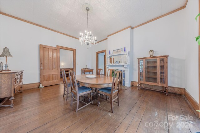 dining space with crown molding, hardwood / wood-style floors, and a notable chandelier