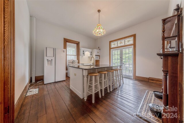 kitchen featuring a breakfast bar area, white cabinets, and dark hardwood / wood-style floors