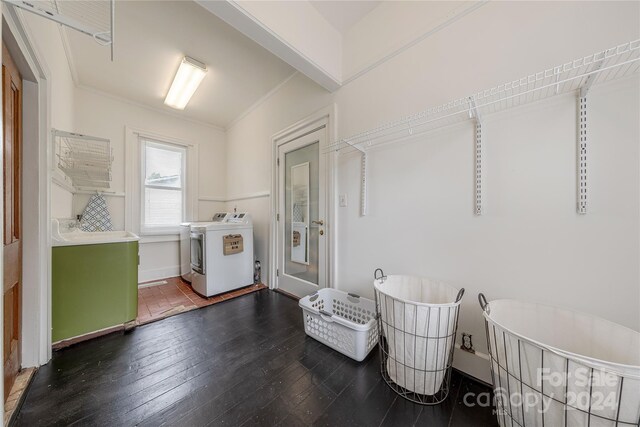 laundry area with dark wood-type flooring, crown molding, and washing machine and dryer