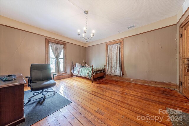 bedroom featuring a chandelier and hardwood / wood-style flooring