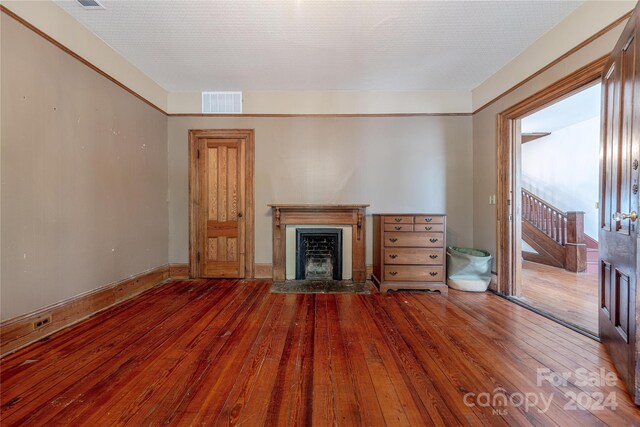 unfurnished living room with a textured ceiling and hardwood / wood-style flooring