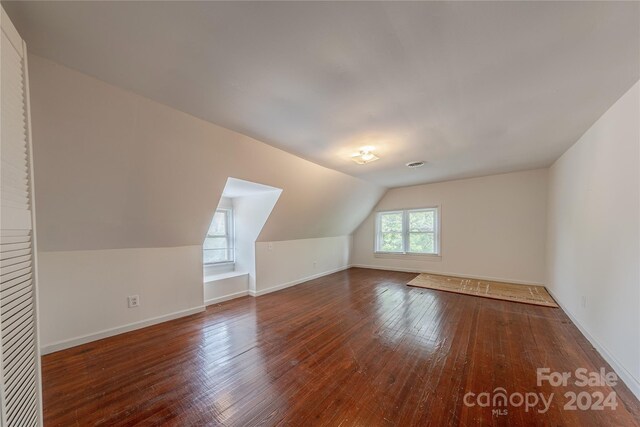 bonus room with lofted ceiling and dark hardwood / wood-style floors