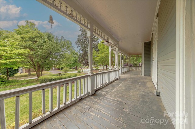 deck featuring covered porch and a lawn