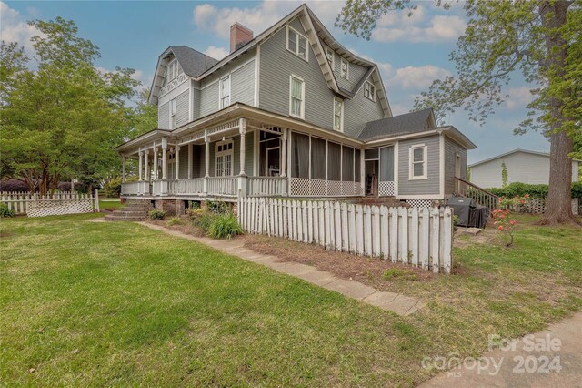 view of front of home featuring a front lawn and a sunroom