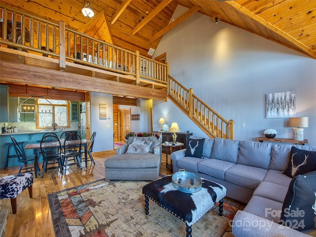 living room featuring high vaulted ceiling, sink, light wood-type flooring, and wood ceiling