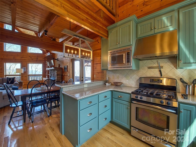 kitchen with beamed ceiling, light hardwood / wood-style floors, kitchen peninsula, and stainless steel appliances