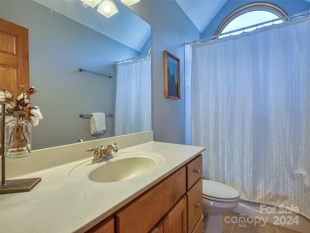 bathroom with lofted ceiling, toilet, vanity with extensive cabinet space, and tile flooring